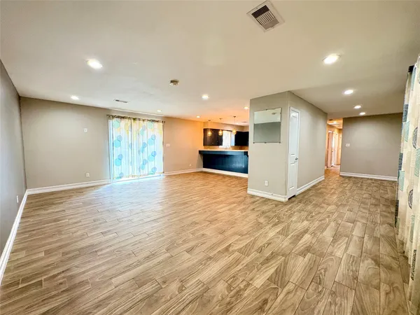 a view of an empty room with wooden floor