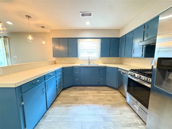 a kitchen with stainless steel appliances granite countertop a sink counter space and cabinets