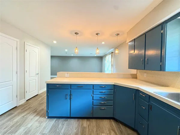 a view of a kitchen with a sink and wooden cabinets