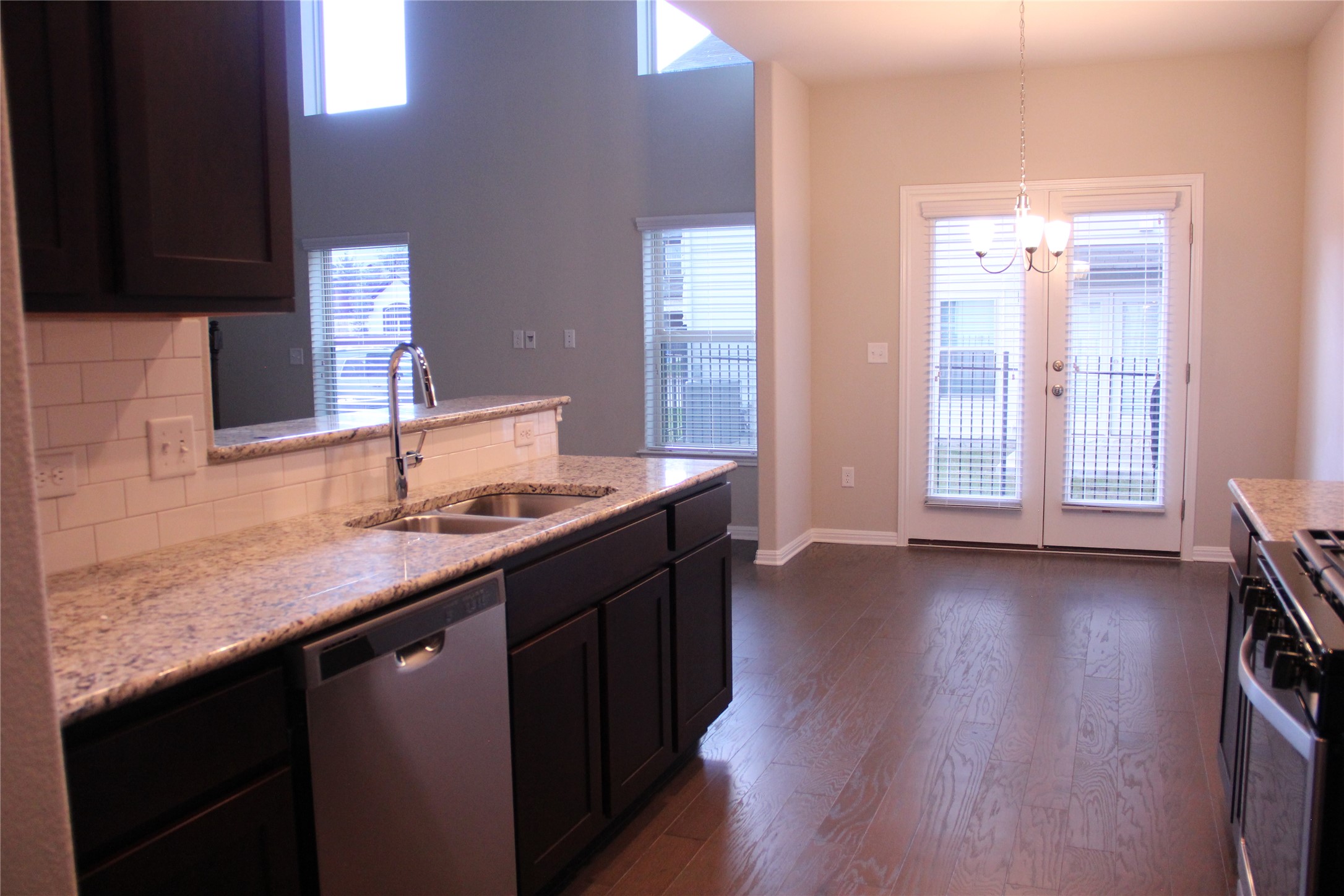 1612 Airedale Road Austin, TX 78748 - Photo 9 of 26 Kitchen with light stone countertops, stainless steel dishwasher, dark wood-style floors, and range with gas stovetop