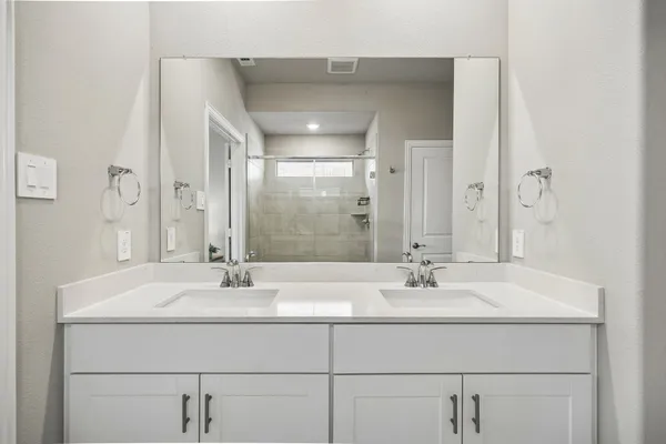 a en suite bathroom with double sink and a large mirror