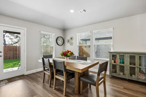 a kitchen with a dining table chairs and refrigerator