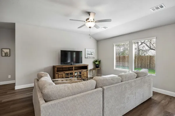 a living room with furniture a flat screen tv and a large window
