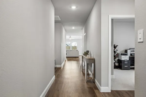 a view of a hallway view with wooden floor and living room