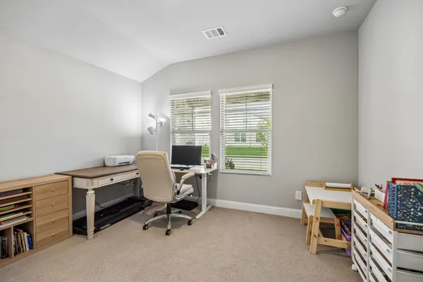 a view of a workspace with furniture and a window