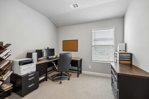 a view of a workspace with furniture and a window