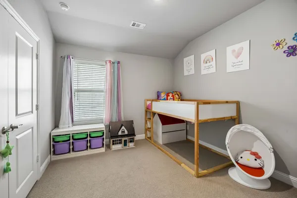 a view of a bedroom with baby toys and a window