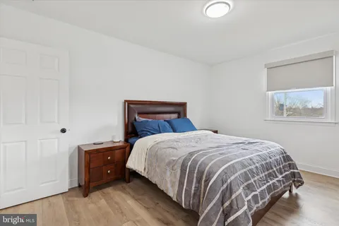 a bedroom with a bed and painting on the wall