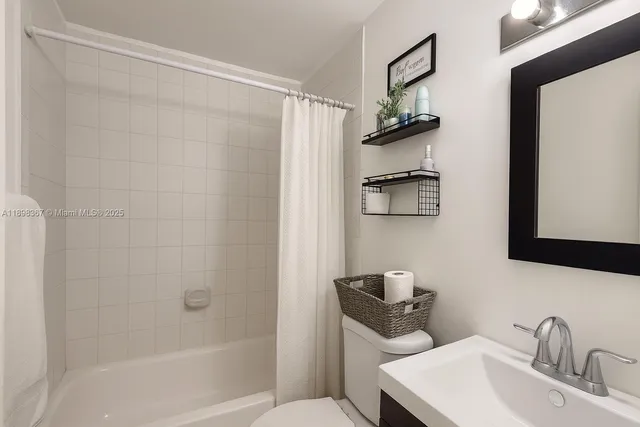 a bathroom with a granite countertop sink mirror toilet and shower