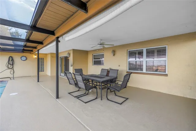 a patio with table and chairs and potted plants