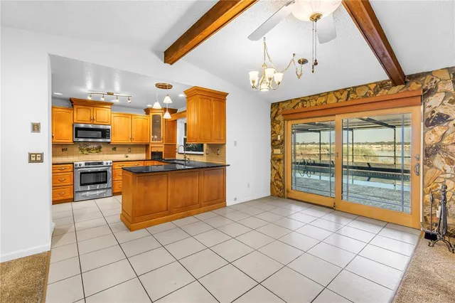 a large kitchen with stainless steel appliances granite countertop a stove and cabinets