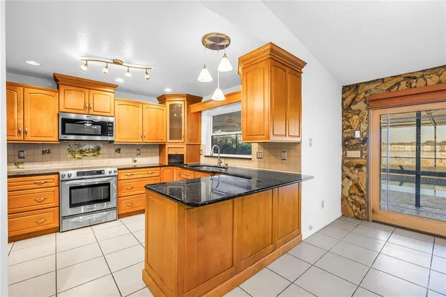 a kitchen with stainless steel appliances granite countertop a stove a sink and a refrigerator