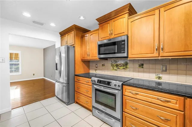 a kitchen with stainless steel appliances granite countertop a refrigerator and a sink