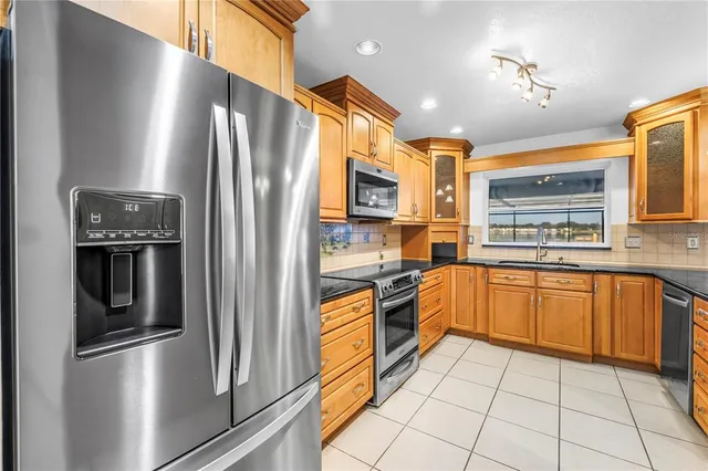 a kitchen with stainless steel appliances granite countertop a refrigerator and a stove top oven