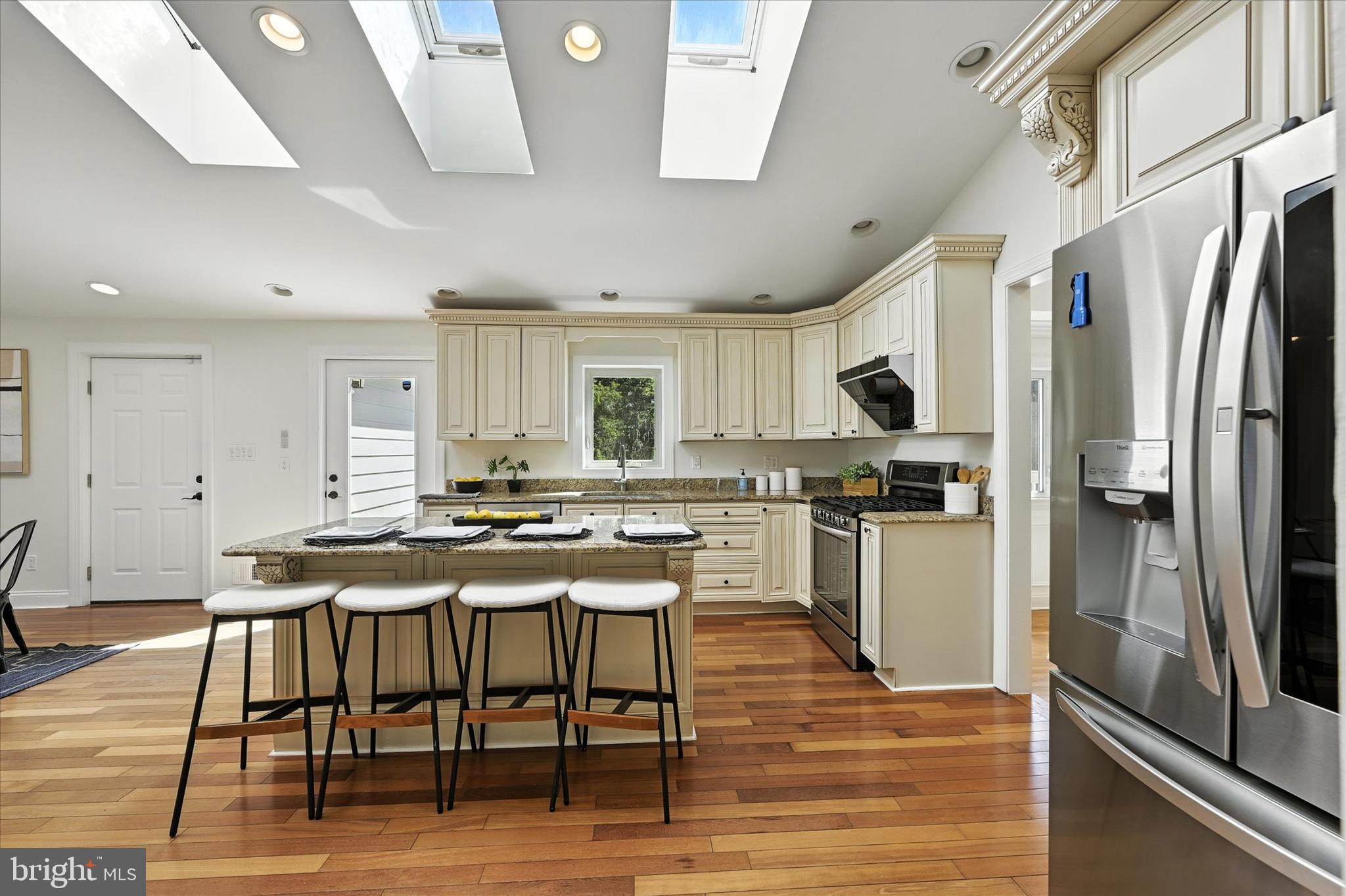 12325 Falls Road Cockeysville, MD 21030 - Photo 12 of 40 a kitchen with stainless steel appliances kitchen island granite countertop a table chairs stove and refrigerator