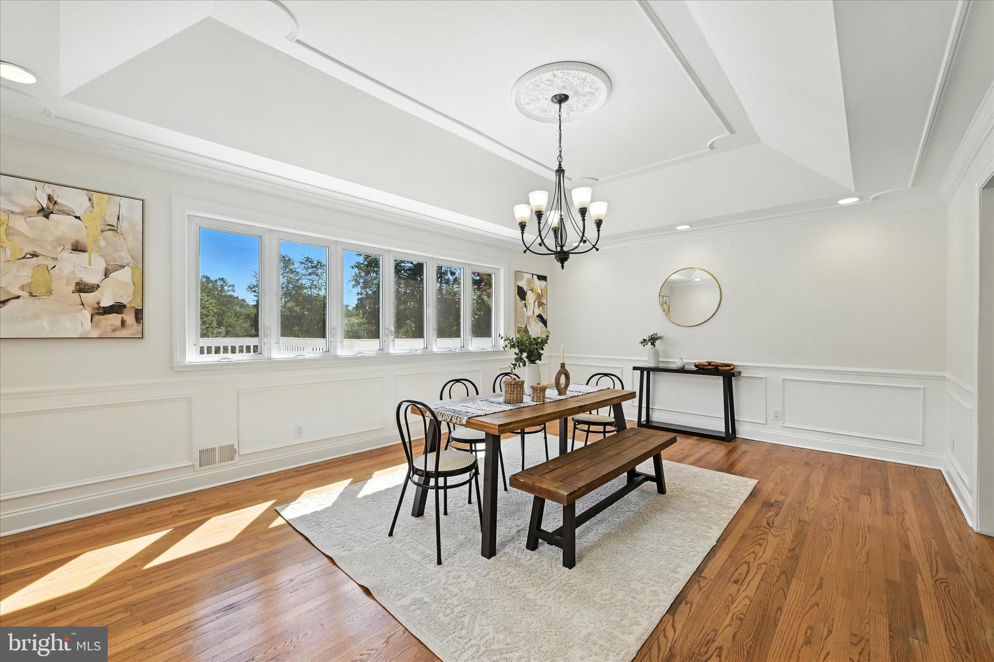 12325 Falls Road Cockeysville, MD 21030 - Photo 17 of 40 a dining room with wooden floor a chandelier a wooden table and chairs