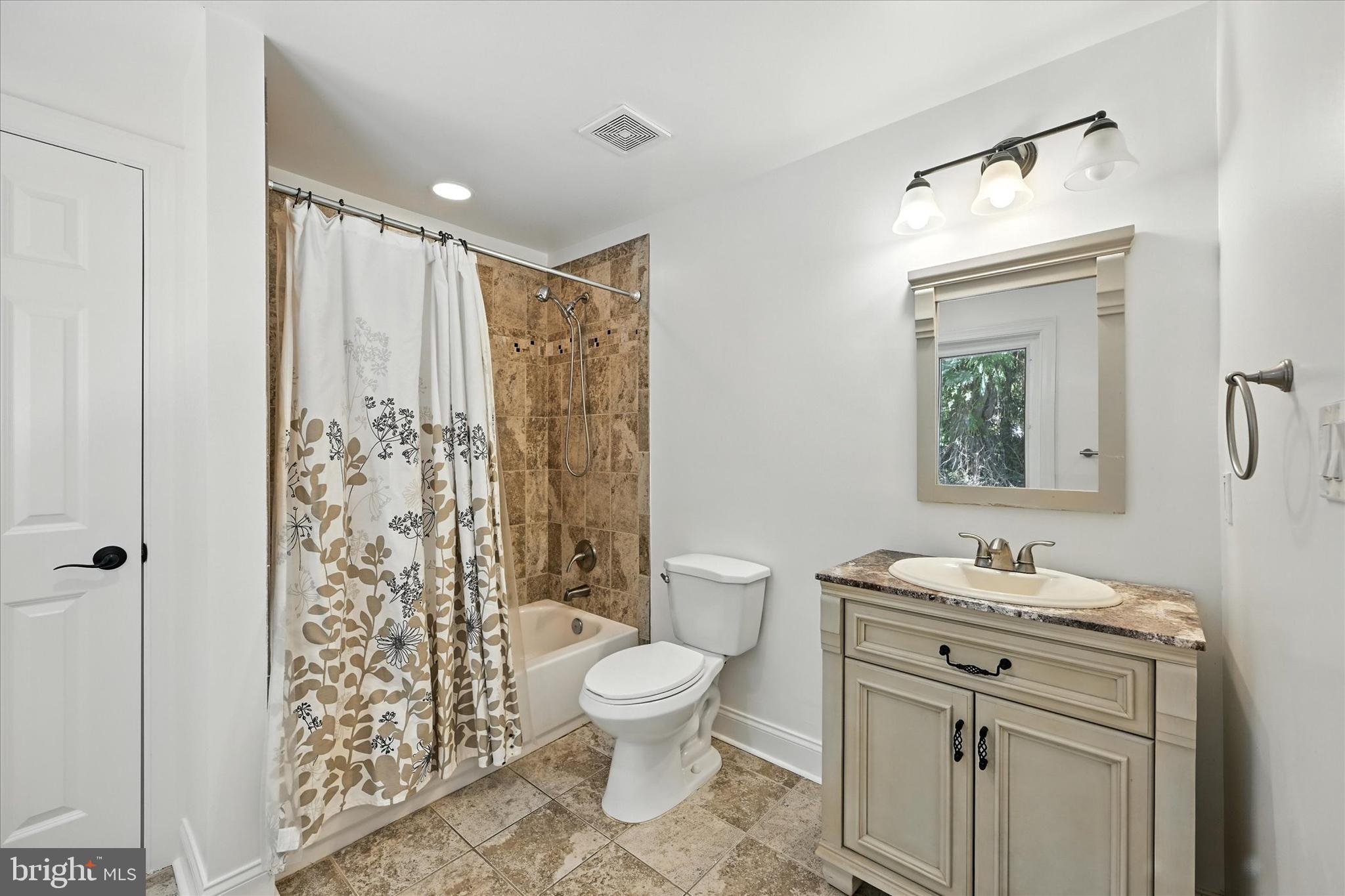 12325 Falls Road Cockeysville, MD 21030 - Photo 28 of 40 a bathroom with a granite countertop sink toilet a mirror and shower
