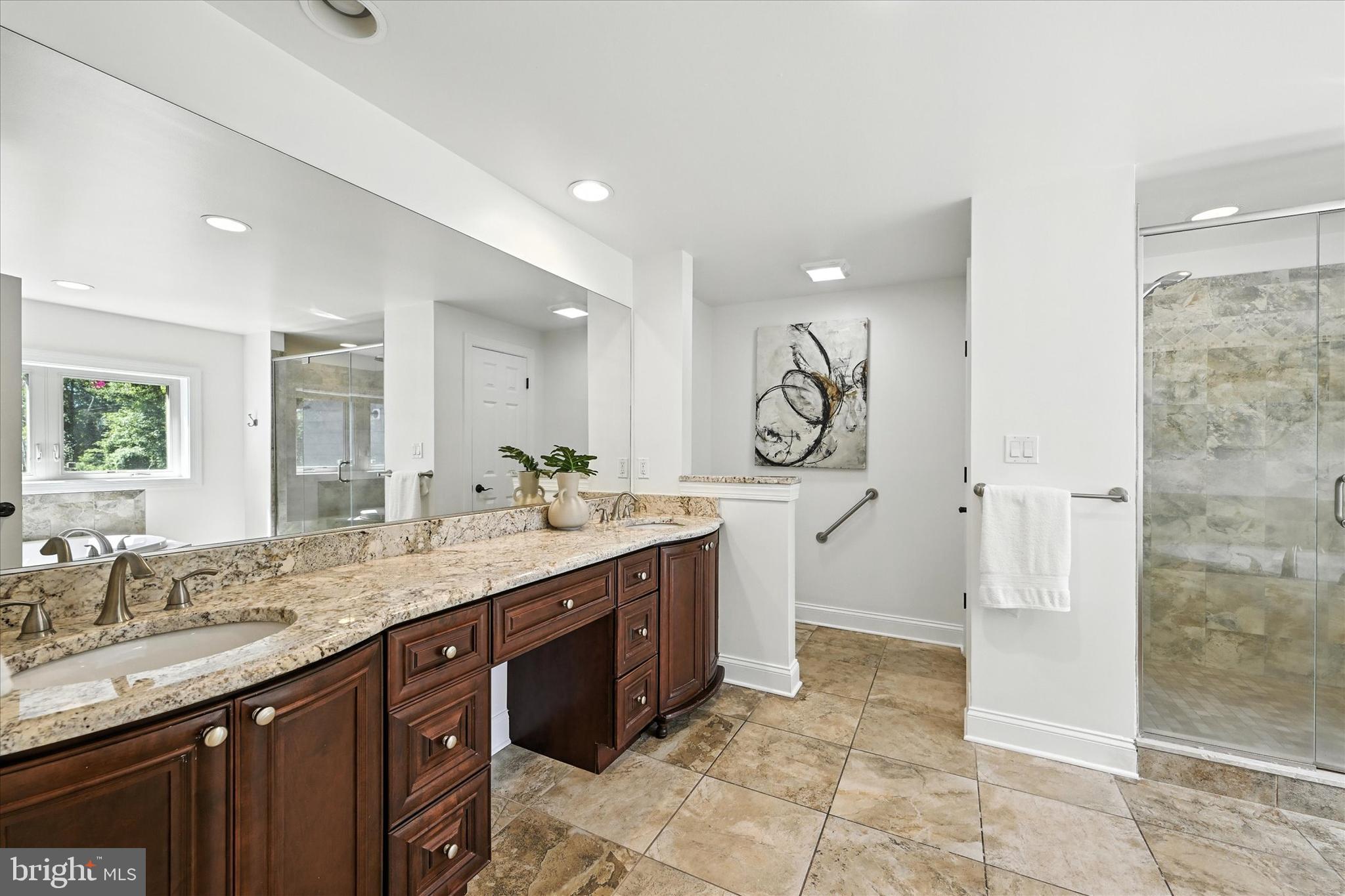 12325 Falls Road Cockeysville, MD 21030 - Photo 30 of 40 a spacious bathroom with a granite countertop sink a mirror and a shower