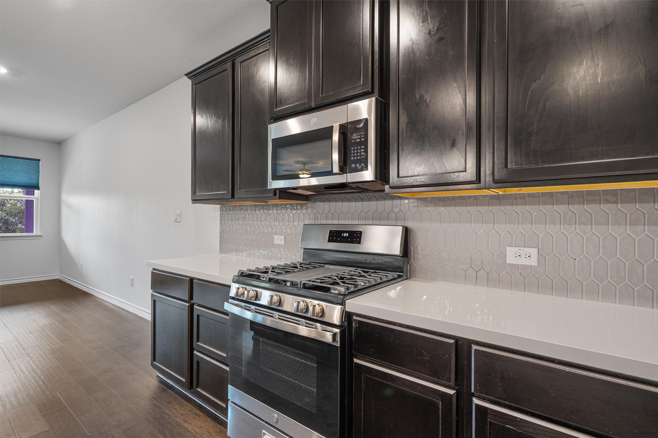 104 Stinchcomb Road Hutto, TX 78634 - Photo 8 of 40 Featuring stainless steel appliances, white quartz countertops, pendant lighting, a large island with space for counter seating, and a kitchen reverse osmosis system.
