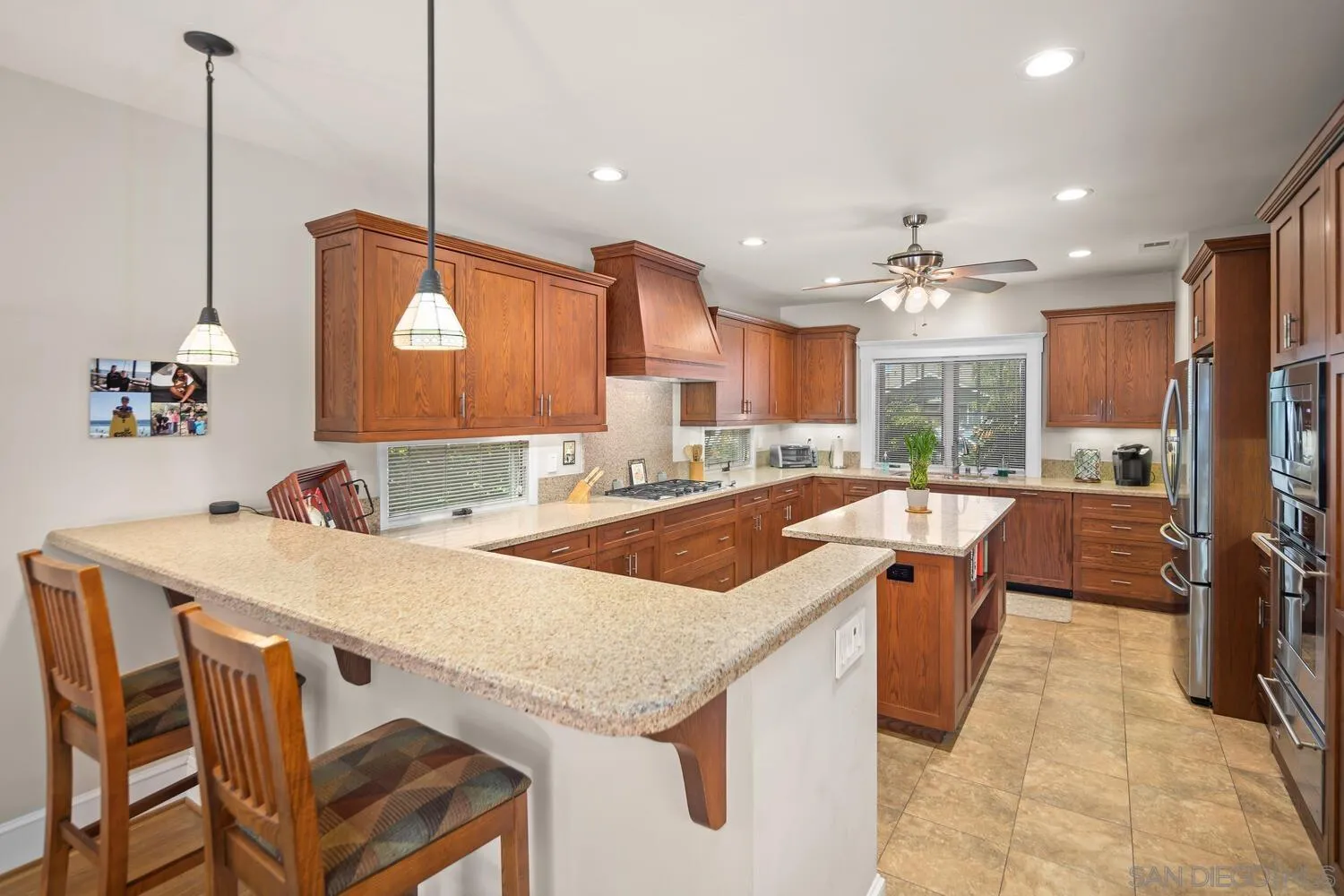 911 B Avenue Coronado, CA 92118 - Photo 15 of 45 a open kitchen with stainless steel appliances granite countertop a sink a stove and a refrigerator with wooden floor