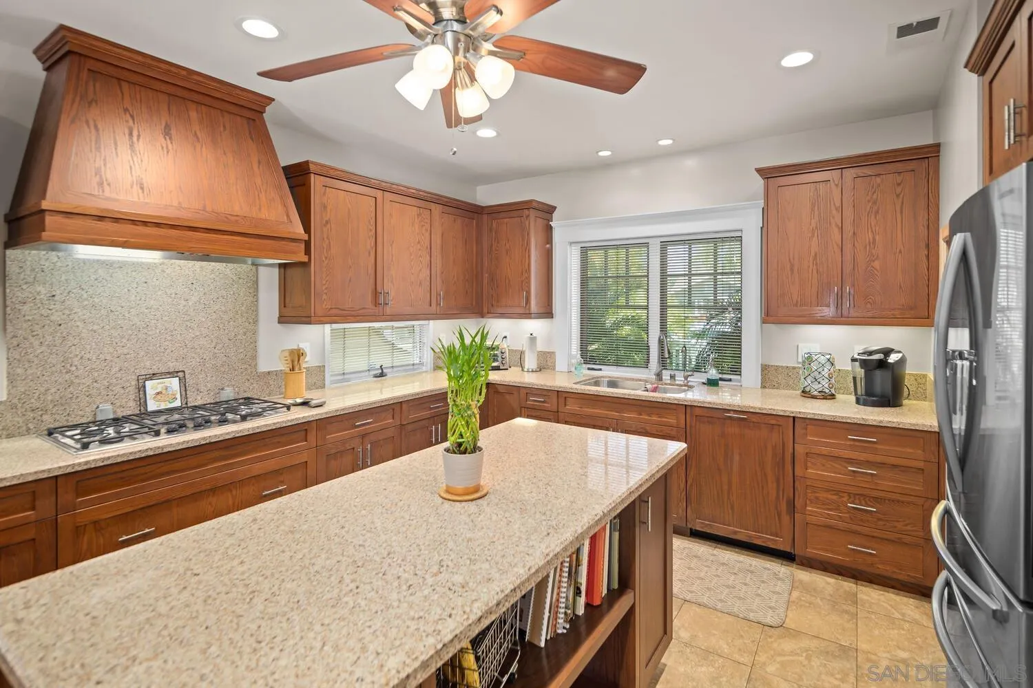 911 B Avenue Coronado, CA 92118 - Photo 17 of 45 a kitchen with stainless steel appliances granite countertop a sink a stove cabinets counter space and living room view
