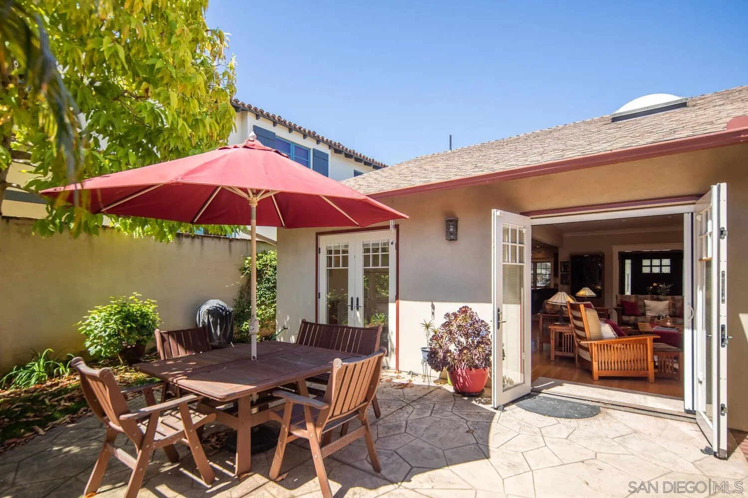 911 B Avenue Coronado, CA 92118 - Photo 34 of 45 a view of a patio with table and chairs under an umbrella with a fire pit