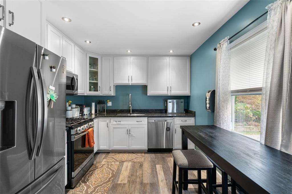 420 Donnell Road Lower Burrell, PA 15068 - Photo 11 of 33 a kitchen with stainless steel appliances granite countertop a refrigerator a sink dishwasher a stove and white countertops with wooden floor