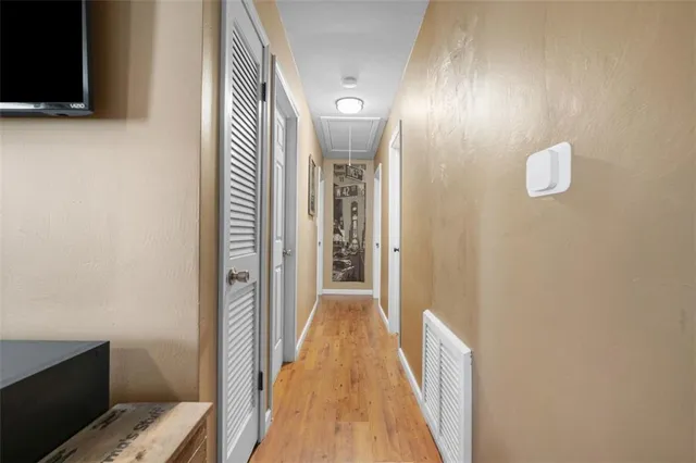 a view of a hallway with wooden floor and staircase