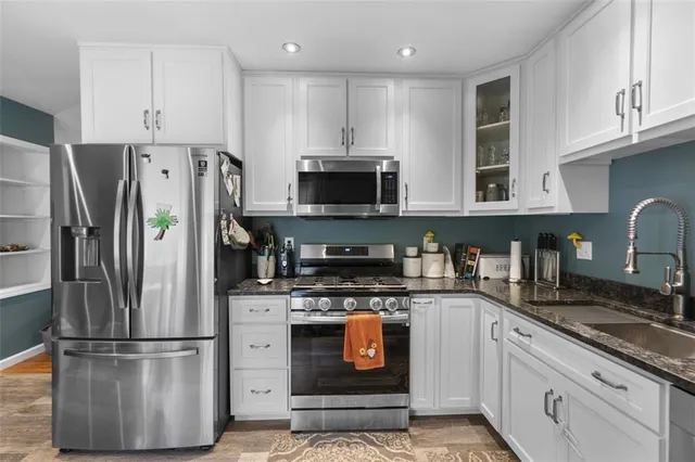 a kitchen with stainless steel appliances granite countertop a refrigerator stove and sink