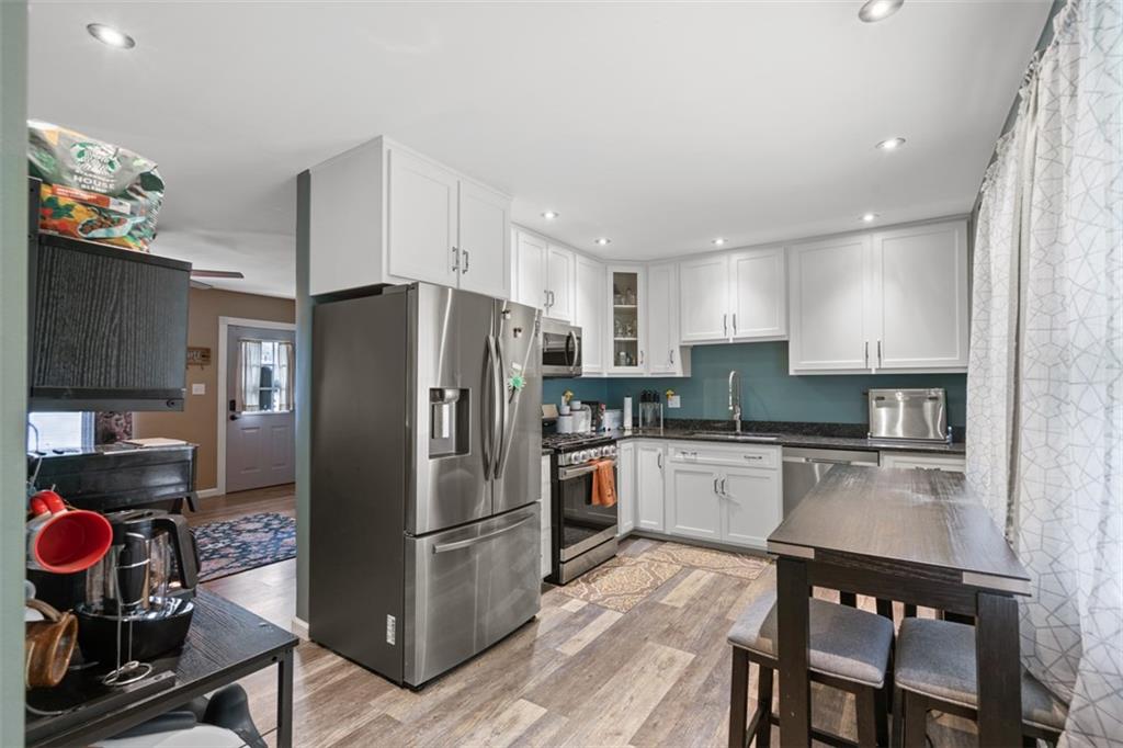 420 Donnell Road Lower Burrell, PA 15068 - Photo 10 of 33 a kitchen with a refrigerator a stove and a wooden cabinets