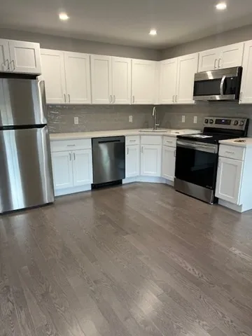 a kitchen with stainless steel appliances granite countertop a refrigerator a stove a sink and a microwave