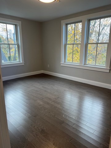 328 Bank Street, Unit 21 Harwich, MA 02645 - Photo 6 of 8 an empty room with wooden floor and windows