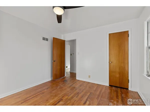 a view of an empty room with wooden floor
