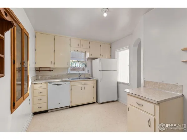 a kitchen with white cabinets and white appliances