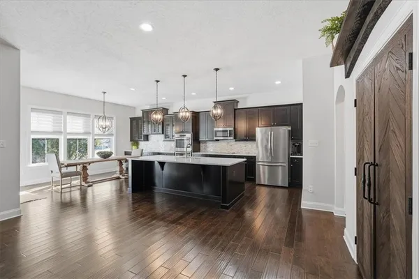 a view of a kitchen area kitchen island dining table wooden floor and window