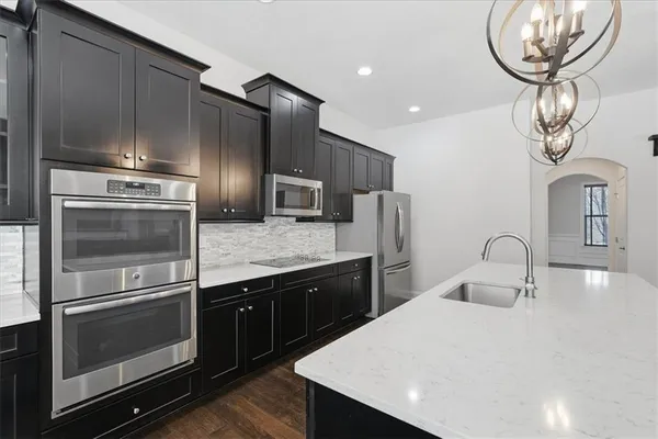 a kitchen with stainless steel appliances a refrigerator and wooden cabinets