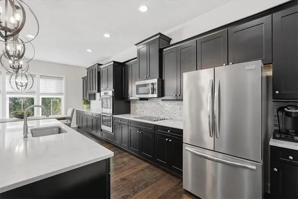 a kitchen with a sink stove and wooden floor