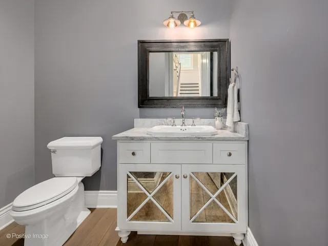 a bathroom with a sink a toilet and a mirror