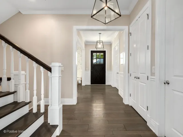 a view of a hallway with wooden floor and staircase