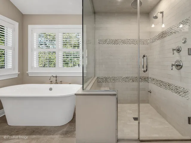a bathroom with a bathtub and next to a window