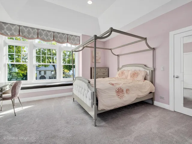 a bedroom with a bed next to a large window with the outer view