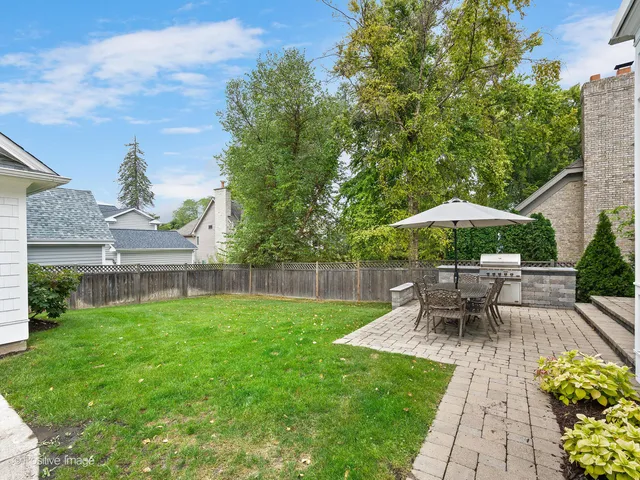 a view of a patio with table and chairs under an umbrella