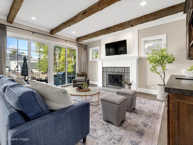 a living room with furniture a large window and a fireplace