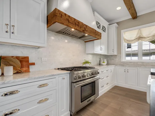 a kitchen with stainless steel appliances granite countertop a stove and a white cabinets