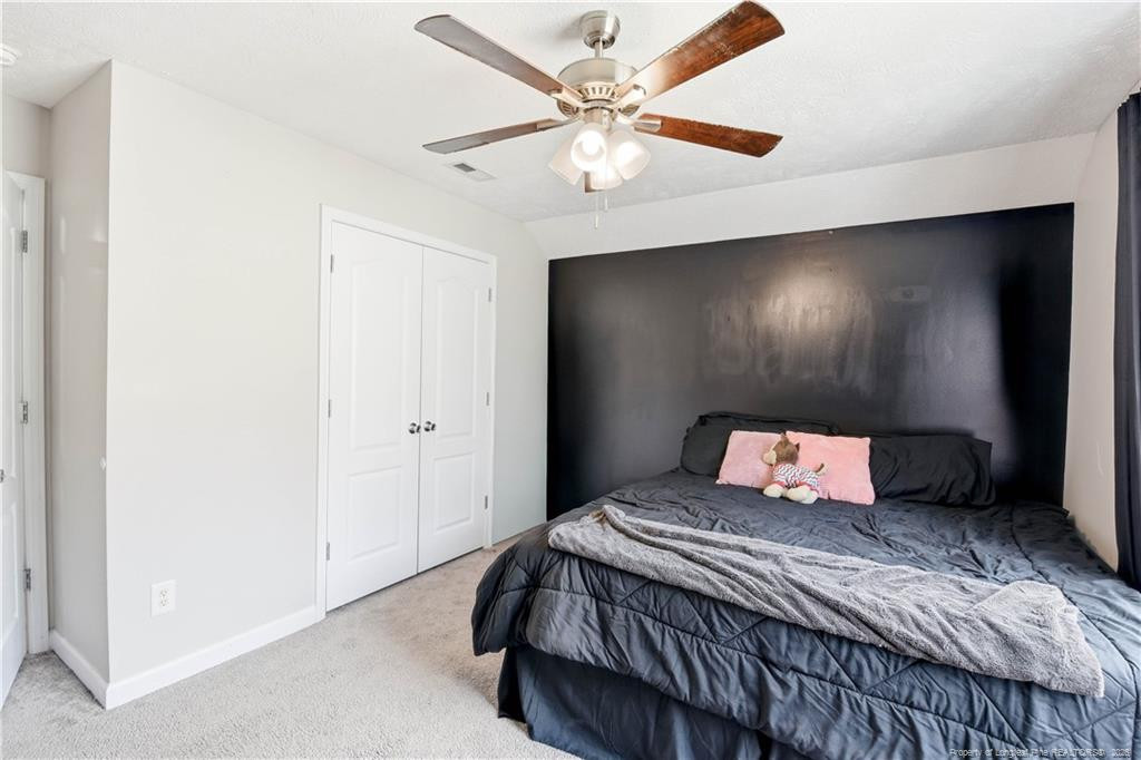 212 Lennox Loop Raeford, NC 28376 - Photo 38 of 47 a bedroom with a large bed and a chandelier