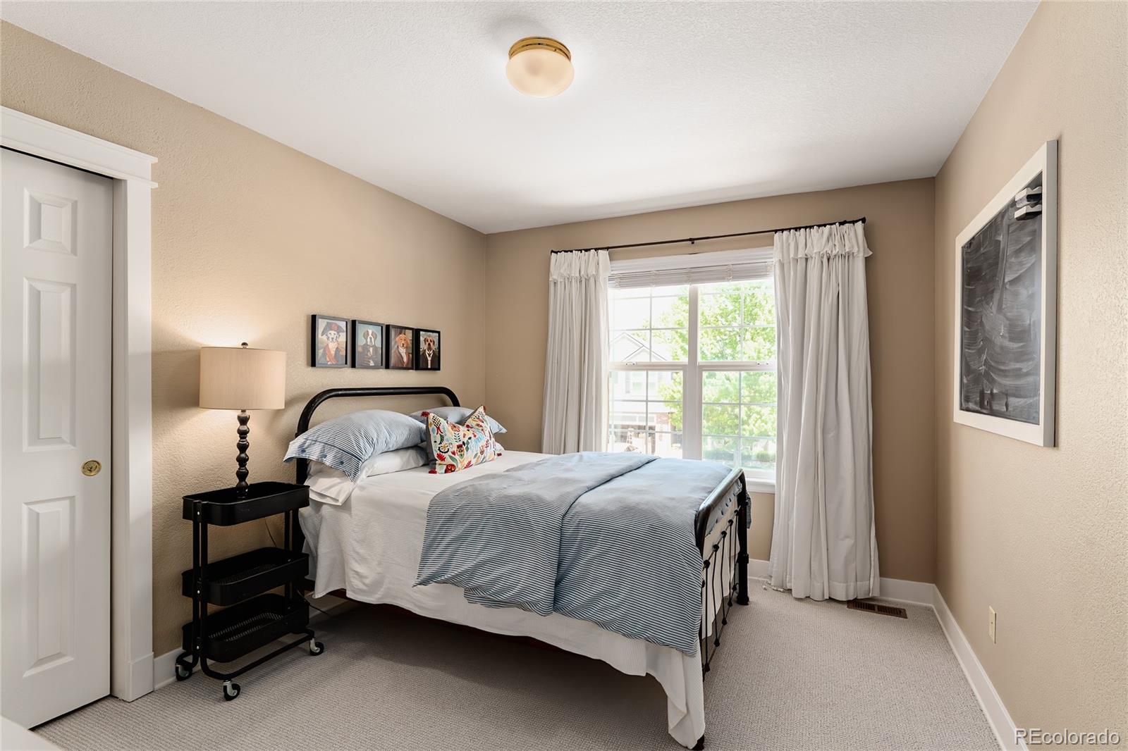 9441 South Hackberry Lane Highlands Ranch, CO 80129 - Photo 33 of 50 a bedroom with a bed and large window
