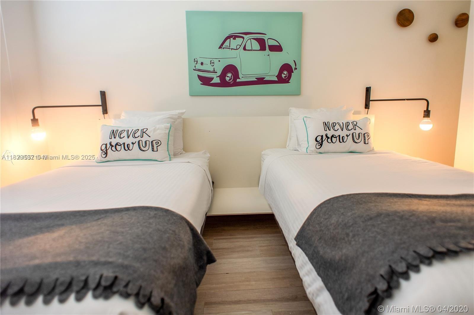 285 Sunrise Drive, Unit 108 Key Biscayne, FL 33149 - Photo 5 of 9 a bedroom with a bed and painting on the wall