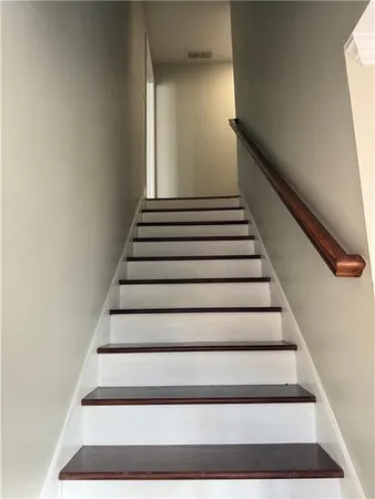 a view of a livingroom with wooden floor a ceiling fan and windows