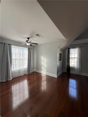 a view of empty room with wooden floor