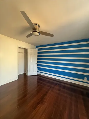 an empty room with wooden floor and window